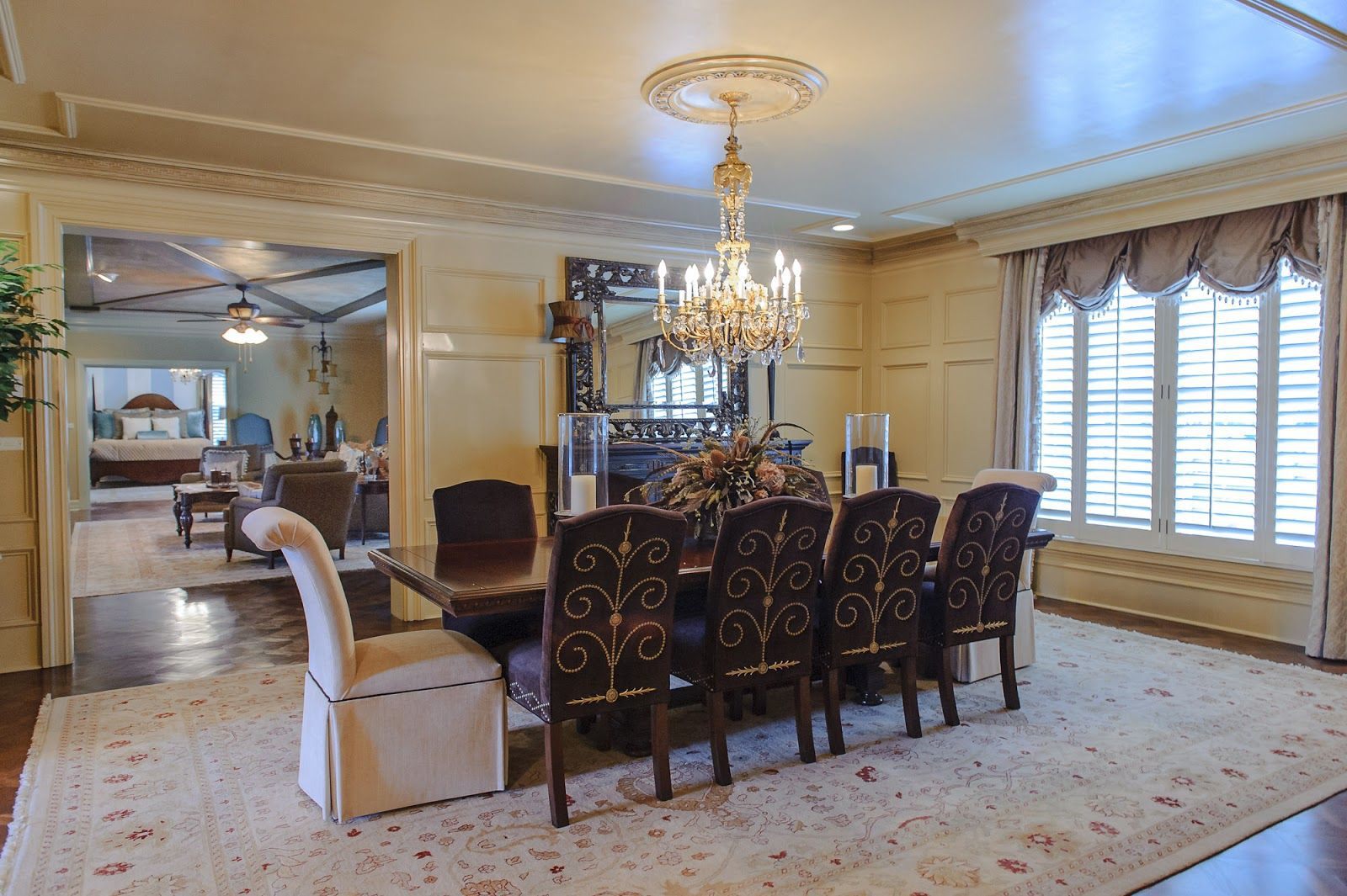 An elegant, staged formal dining room with a polished table and fresh centerpiece, photographed for a real estate listing